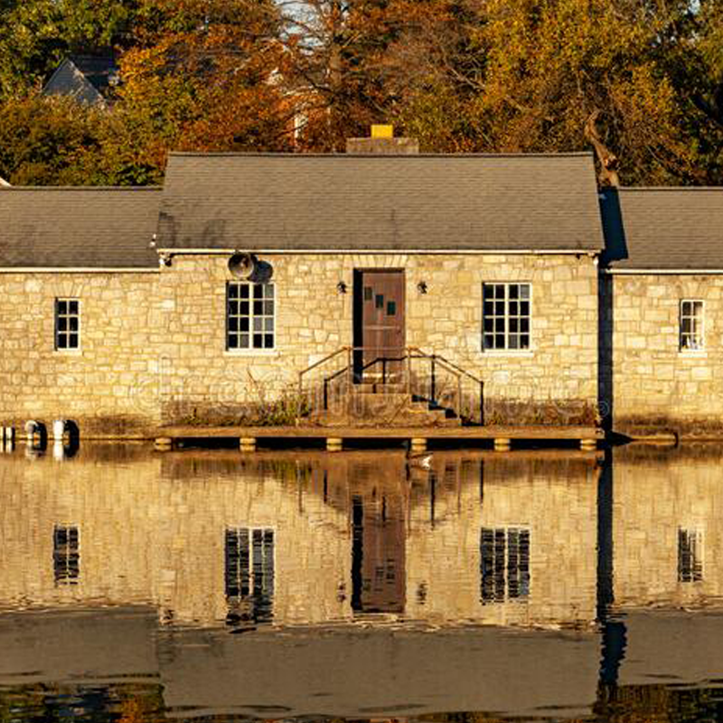 A Stone building reflected on the face of a body of water